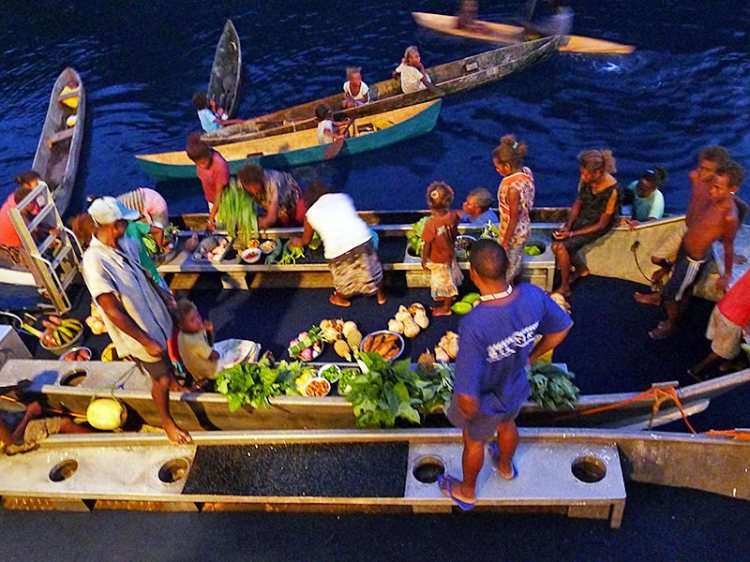 Local villagers tie up in their canoes to sell us fresh fruit and veges, Russell Islands